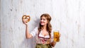 Woman in traditional bavarian dress holding beer and pretzel Royalty Free Stock Photo