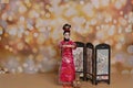 A woman in a traditional Chinese dress on the background of fireworks welcomes guests. The concept of the Chinese New Year. A doll