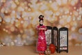 A woman in a traditional Chinese dress on the background of fireworks welcomes guests. The concept of the Chinese New Year. A doll