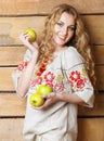 Woman in traditional dress holding apples in her hands