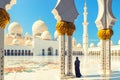 Woman in traditional dress inside Sheikh Zayed Mosque Ã¢â¬â tourist wearing black abaya visiting famous arabian religious temple Royalty Free Stock Photo