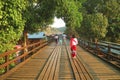 Woman in Traditional Mon Dress Walking on the Iconic Mon Bridge in Sangkhlaburi of Thailand