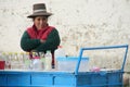 Woman in traditional peruvian hat selling food