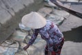 A woman in a straw hat measures the level of sea water
