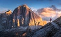 Woman on the trail looking on high mountain peak at sunset