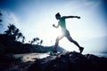 Runner running at rocky mountain top on seaside