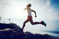 Woman trail runner running to rocky mountain top Royalty Free Stock Photo