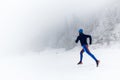 Woman trail running on snow in winter mountains Royalty Free Stock Photo