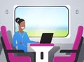 Woman train passenger listening audio book with headphones african american girl sitting pink armchair railway traveling Royalty Free Stock Photo