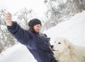 Woman train white dog in winter forest