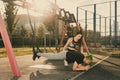 Woman trainer with braids hairstyle helping man man with mohawk hairstyle doing exercise outdoors using overhead training Royalty Free Stock Photo