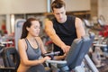 Woman with trainer on exercise bike in gym Royalty Free Stock Photo