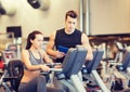 Woman with trainer on exercise bike in gym Royalty Free Stock Photo