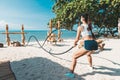 Woman training with battle ropes in Eco gym on the beach Royalty Free Stock Photo