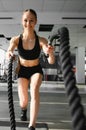 Woman training with battle ropes in gym Royalty Free Stock Photo