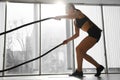 Woman training with battle ropes in gym Royalty Free Stock Photo