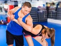 Woman is training captures with man on the self-defense course in gym. Royalty Free Stock Photo