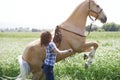 Woman training horse to rear up