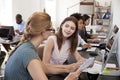 Woman training new female employee in an open plan office Royalty Free Stock Photo