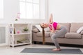 Woman training yoga in twisting awkward pose.