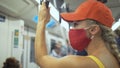 Woman travel caucasian ride at overground train airtrain with wearing protective medical mask. Girl tourist at airtrain Royalty Free Stock Photo
