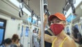 Woman travel caucasian ride at overground train airtrain with wearing protective medical mask. Girl tourist at airtrain Royalty Free Stock Photo