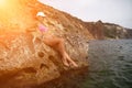 Woman travel sea. Pink bikini tourist captures sea memory, posing on beach amidst volcanic mountains for travel