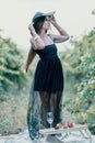 Woman travel winery. Portrait of happy woman holding glass of wine and enjoying in vineyard. Elegant young lady in hat Royalty Free Stock Photo