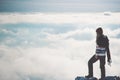 Woman Traveler alone on cliff over clouds