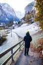 woman traveler in amazing touristic alpine village in winter with famous church and Staubbach waterfall Lauterbrunnen