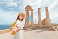 Woman Traveler with backpack Enjoying great view og the ancient Greek Acropolis with flag in hands Royalty Free Stock Photo