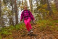 Woman traveler descends from a hill in the autumn forest, radial blur background