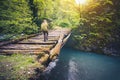 Woman Traveler with backpack hiking on bridge over river