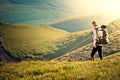 Woman Traveler with Backpack hiking in Mountains