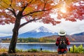Woman traveler with backpack looking to Fuji mountains in Autumn, Japan.