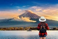 Woman traveler with backpack looking to Fuji mountains at sunset in Japan.