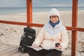 Woman Traveler With A Backpack, Map And Phone. Theme Travel and Navigation in Europe. Girl in hat and jacket with a backpack in Royalty Free Stock Photo