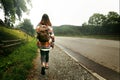 woman traveler with backpack walking down the road in mountains, travel concept, space for text Royalty Free Stock Photo
