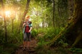 Woman traveler with backpack walking in rain forest.