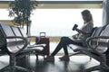 Woman traveler with baggage sits in the waiting room of the airport and is waiting for the flight Royalty Free Stock Photo