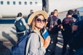 Woman traveler boarding on plane holding passport. Happy passenger with backpack standing in line ready for flight