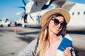 Woman traveler boarding on plane holding passport tickets. Happy passenger with backpack ready for flight