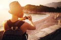 Woman traveler with camera taking photo near sea Royalty Free Stock Photo