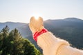 Woman traveler in christmas gloves holding snow in the shape of a heart on a background of mountains with sunbeams. Winter travell