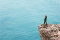 Woman traveler on cliff edge above sea Travel Lifestyle success motivation concept adventure active vacations outdoor harmony Royalty Free Stock Photo