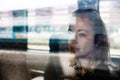 Woman traveler contemplating outdoor view from window of train. Young lady on commute travel to work sitting in bus or