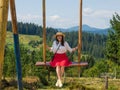 woman traveler enjoying of swinging on heavenly swing and mountain view