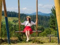 woman traveler enjoying of swinging on heavenly swing and mountain view