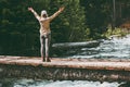 Woman Traveler happy raised hands on bridge over river adventure Travel