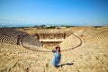 Woman traveler in hat looking at amazing Amphitheater ruins in ancient Hierapolis, Pamukkale, Turkey. Grand panoramic view Royalty Free Stock Photo